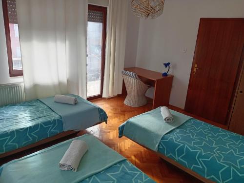 a room with two twin beds and a desk at Nina Apartments in Negotin