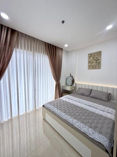 a bedroom with a large bed and a large window at Phú Tài Central Life in Quy Nhon