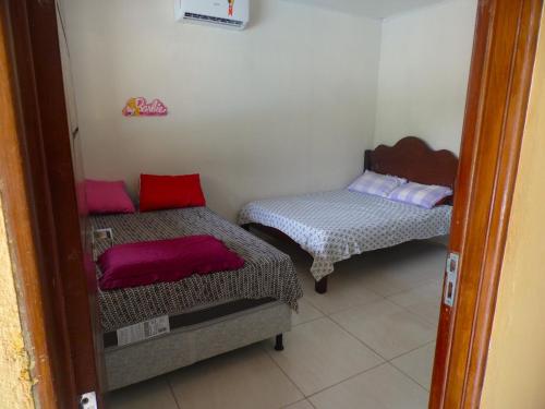 ein Zimmer mit zwei Betten in einem Zimmer in der Unterkunft Bitingui infinity in Japaratinga