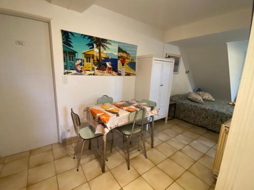 a dining room with a table and chairs and a bed at Bel Horizon in La Celle-sous-Gouzon