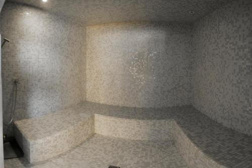 a bathroom with a tub in a room with tiles at SALVEO Suites in Loubens