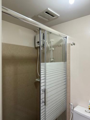 a shower with a glass door in a bathroom at The Cozy Place Stanford 2 in Silang