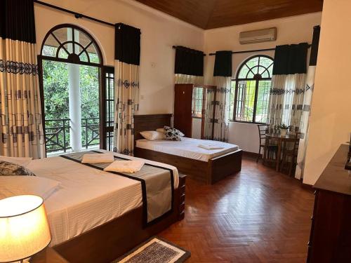 a bedroom with two beds and a window at Kandy Villa in Kandy