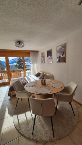 a living room with a table and chairs and a bed at Summit & Spring Studio - Leukerbad in Leukerbad