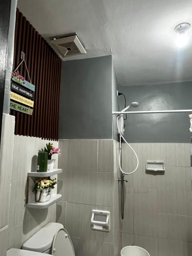 a bathroom with a shower and a toilet at JAN Studio CDO Condo Stay in Lapasan