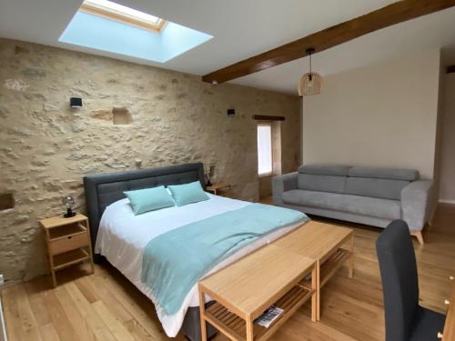 a bedroom with a bed and a couch at SALVEO Suites in Loubens