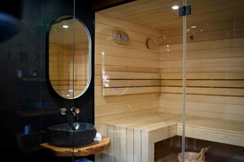 a bathroom with a tub with a sink and a mirror at Magical Wellness Cottage Trvalka in Křimov