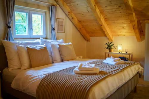 a bedroom with a large bed with towels on it at Magical Wellness Cottage Trvalka in Křimov