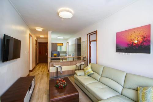 a living room with a couch and a kitchen at Executive Residency by Best Western Nairobi in Nairobi