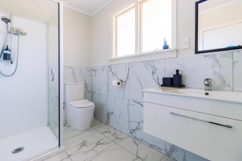 a bathroom with a toilet and a sink and a shower at Belle Bonne Motel in Christchurch