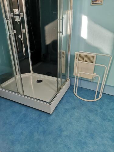 a glass shower with a chair in a room at Maisonnette La Bienvenue in Trainel