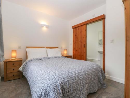 ein Schlafzimmer mit einem Bett und zwei Lampen auf Nachttischen in der Unterkunft Castle Rag in Lydney