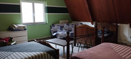a green room with two beds and a window at Le Clos Joli 15 in Molompize
