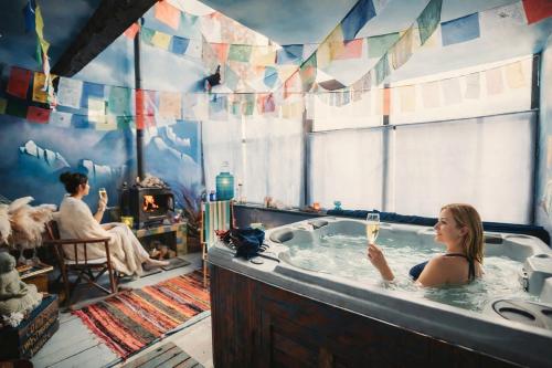 a woman in a bath tub with a glass of wine at Au2 Maison d'Hôtes - Guest House Au2 in Muidorge
