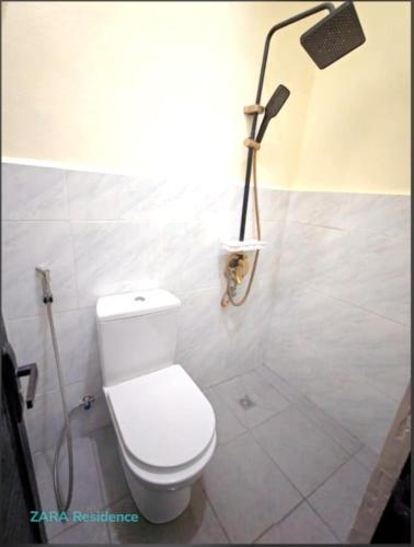 a bathroom with a toilet and a shower at Zara Residence Room1 in Lagao