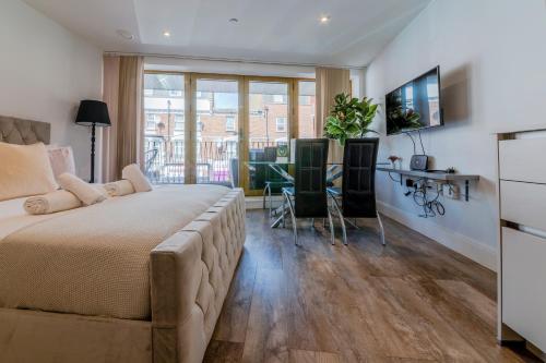 a bedroom with a large bed and a desk at Luxe London Retreat by Aureva Residences in London