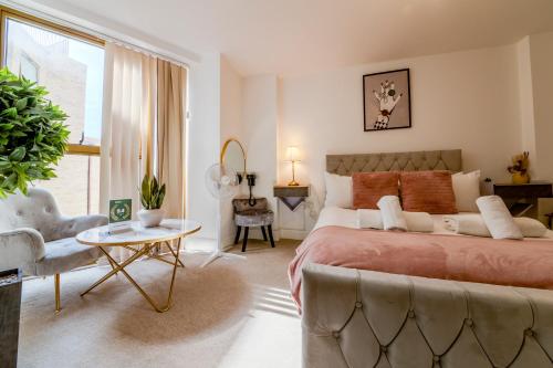 a bedroom with a bed and a couch and a table at Luxe London Retreat by Aureva Residences in London