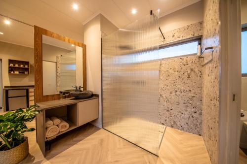 a shower with a glass door in a bathroom at LEO Sky Farm Cottages in Simondium
