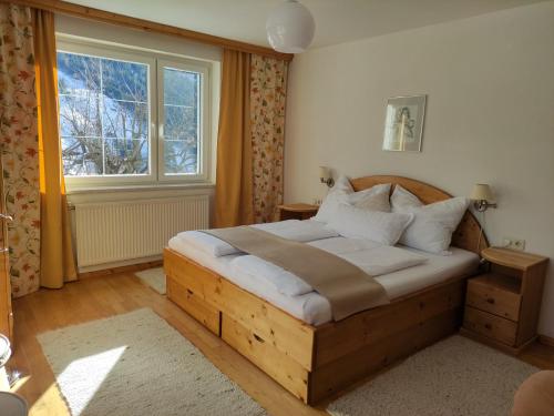a bedroom with a wooden bed and a window at Ferienwohnung Kerschbaumer in Rangersdorf