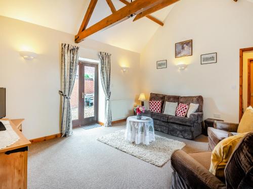 a living room with a couch and a table at Pear Tree Cottage in Banham