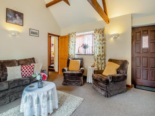 a living room with couches and chairs and a table at Pear Tree Cottage in Banham