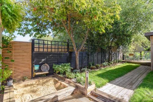 a garden with a tree and a fence at Spacious 4 Bedroom House by Oxford Train Station in Oxford