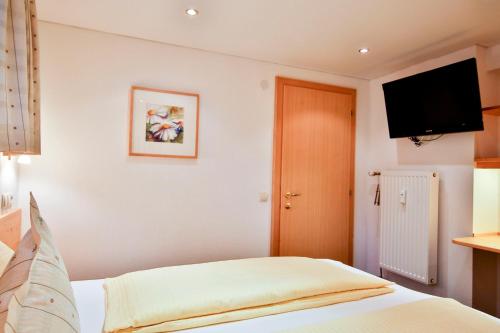 a bedroom with a bed and a flat screen tv at Alpenhaus Montafon by Pferd auf Wolke in Gargellen
