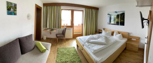 a hotel room with a bed and a couch at Landhaus Engadin in Nauders