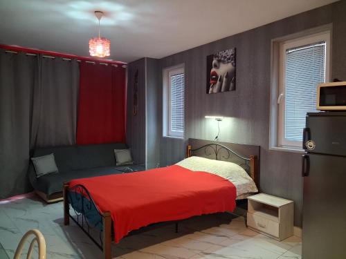 ein Schlafzimmer mit einem Bett mit einer roten Decke in der Unterkunft Studio Nera in Pomorie