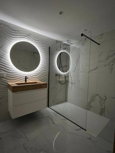 a bathroom with a sink and a mirror at Rare T2 New, Waterfront in Porticcio