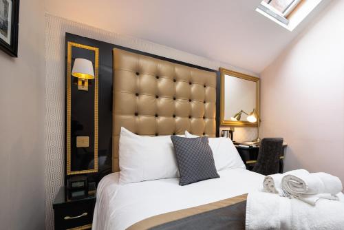 a bedroom with a large bed with a large headboard at Museum Residence Oxford in Oxford