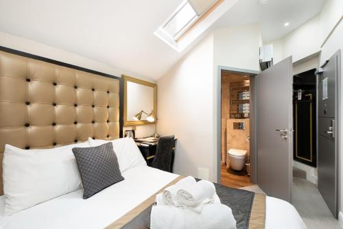 a bedroom with a large white bed with a large headboard at Museum Residence Oxford in Oxford