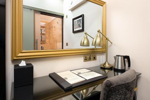 a desk with a mirror and a lamp and a chair at Museum Residence Oxford in Oxford