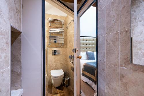 a bathroom with a toilet and a bed in a room at Museum Residence Oxford in Oxford
