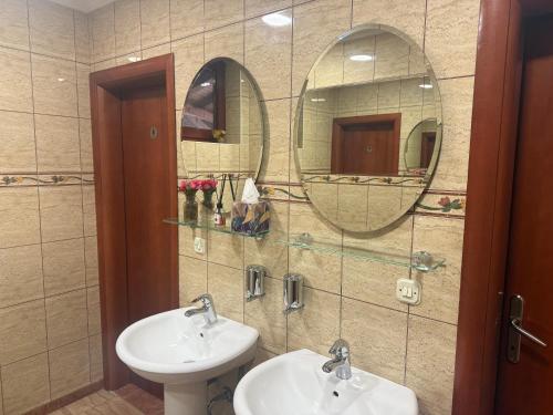a bathroom with two sinks and two mirrors at Motel Alibey in Bugojno