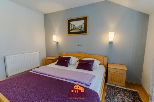 a bedroom with a bed with purple sheets and pillows at Motel Alibey in Bugojno