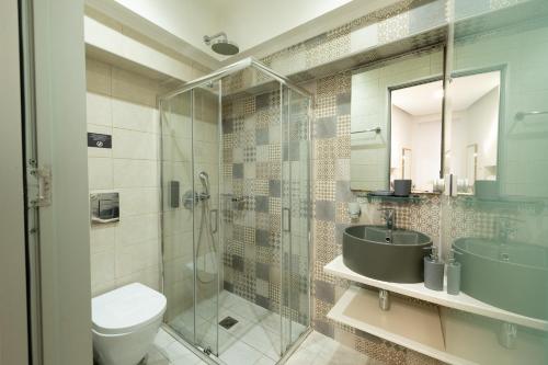a bathroom with a glass shower and a toilet and a sink at Cretan Berry Portou in Chania