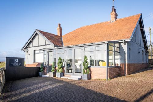 a building with glass windows and a roof at Northern Hideaways, Sunnyside, Otterburn in Otterburn
