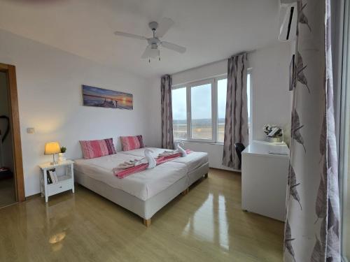 a bedroom with a bed and a large window at Perla View Apartment in Primorsko