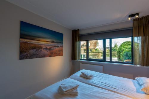 a bedroom with a bed and a large window at Zilte Bries in De Koog