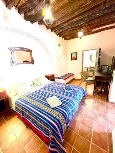 a bedroom with a bed and a table in a room at Casa Amigos Sorvilan - la Bodega in Sorvilán