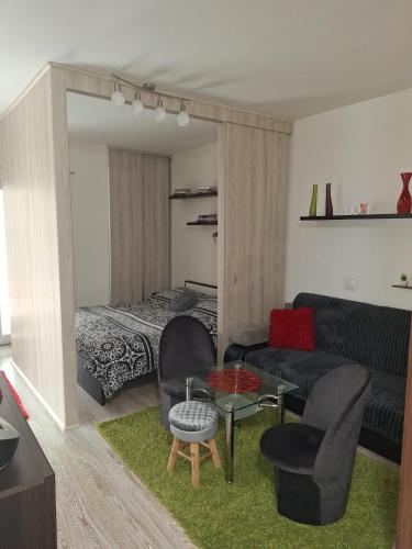 a living room with a couch and a bed at Apartmán Mery in Podhájska