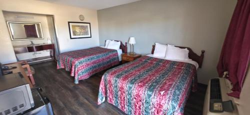 a hotel room with two beds and a tv at Budget Inn in Dothan