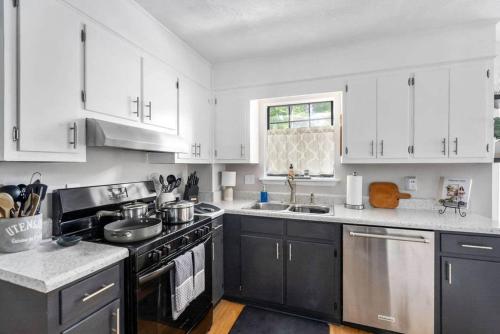 a kitchen with white cabinets and a stove top oven at King 3bedroom, centrally located in Augusta