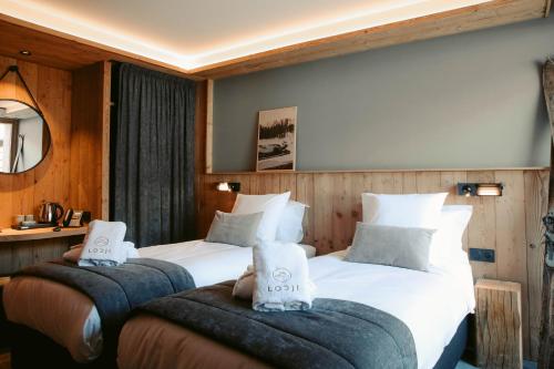 a hotel room with two beds and two chairs at Lodji Hotel & spa in Saint-Martin-de-Belleville