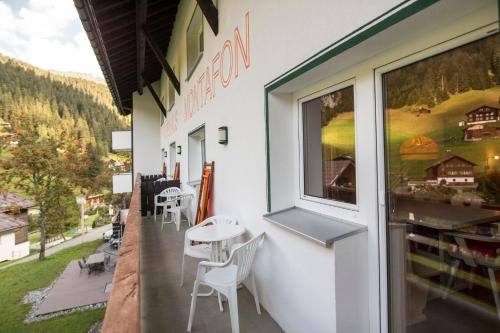 a restaurant with a table and chairs on a balcony at Alpenhaus Montafon by Pferd auf Wolke in Gargellen