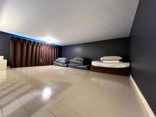 a room with two beds in the corner of a room at イマココホテル in Yogi