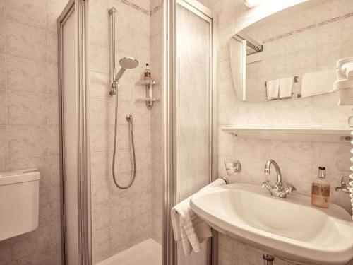 a white bathroom with a shower and a sink at Fermeda in Villnoss