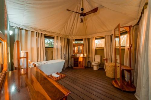 a bathroom with a tub and a toilet and a sink at Mutsviri Game Lodge in Victoria Falls
