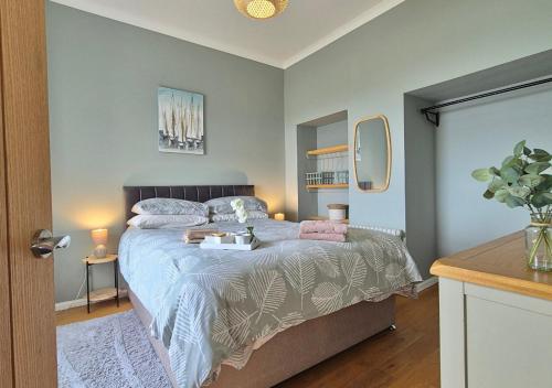 a bedroom with a bed and a table with two lamps at Seaview Cottage in Llanddulas